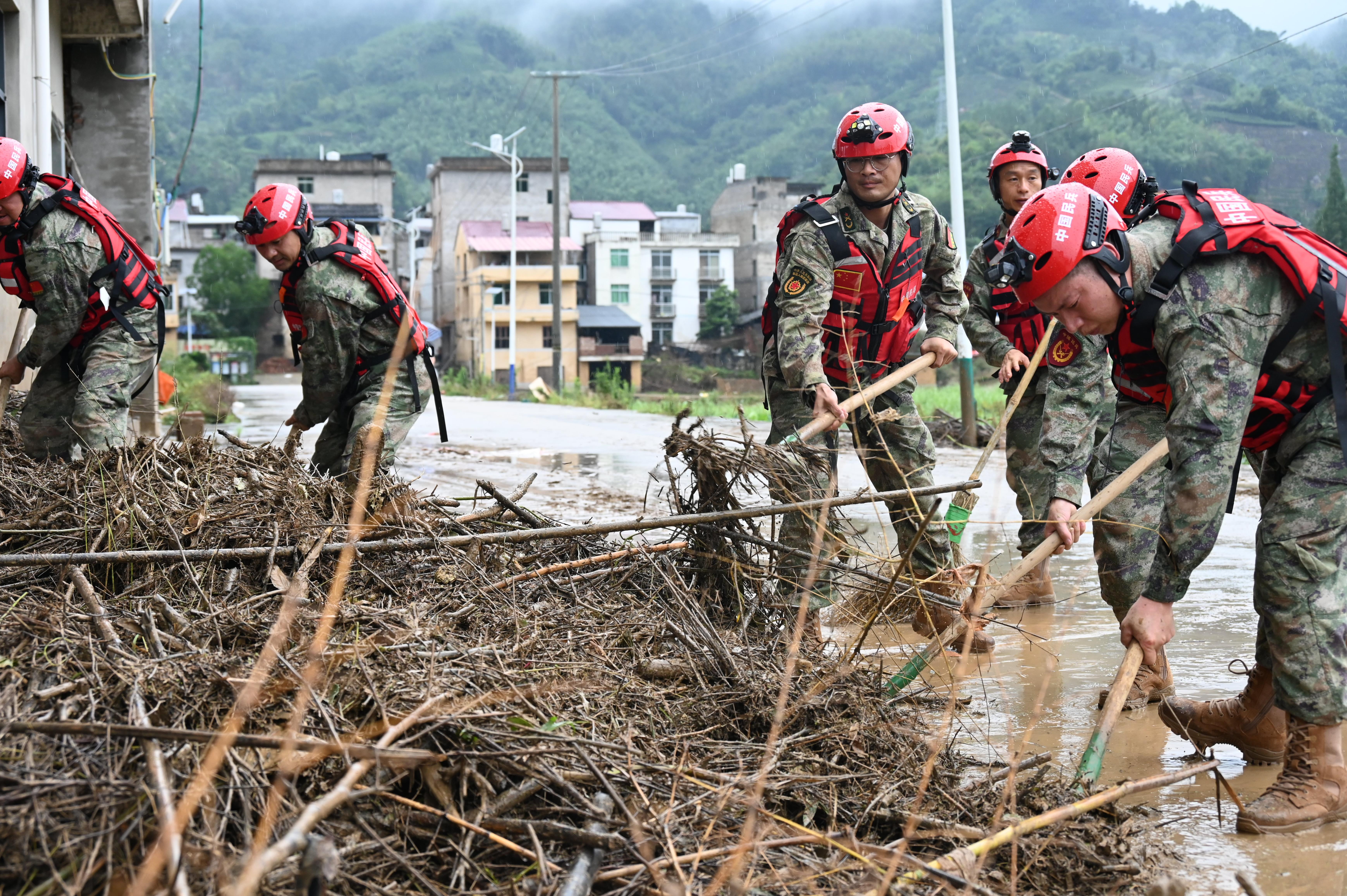 中国大陆近日出现南涝北旱，图福建南平民兵应急分队17日清理大雨及洪涝所带来的淤泥和杂物。（新华社）