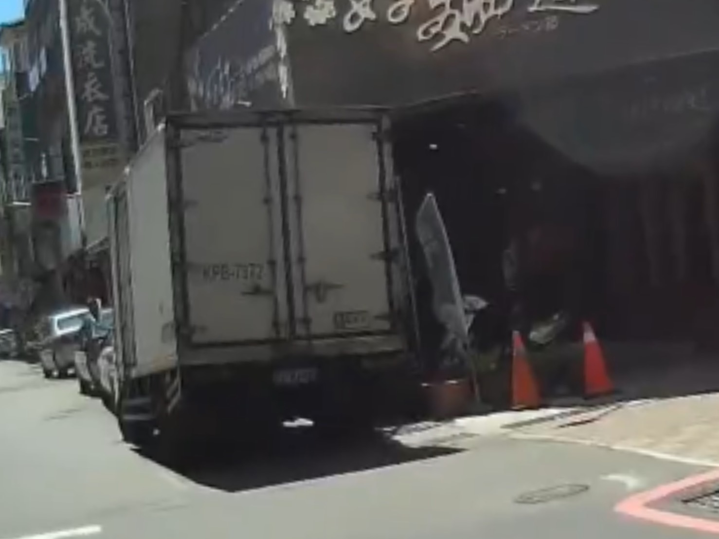 一辆小货车右前轮陷入台南市中西区五妃街道路坑洞内，经警方协助联系拖吊脱困。记者黄宣翰／翻摄