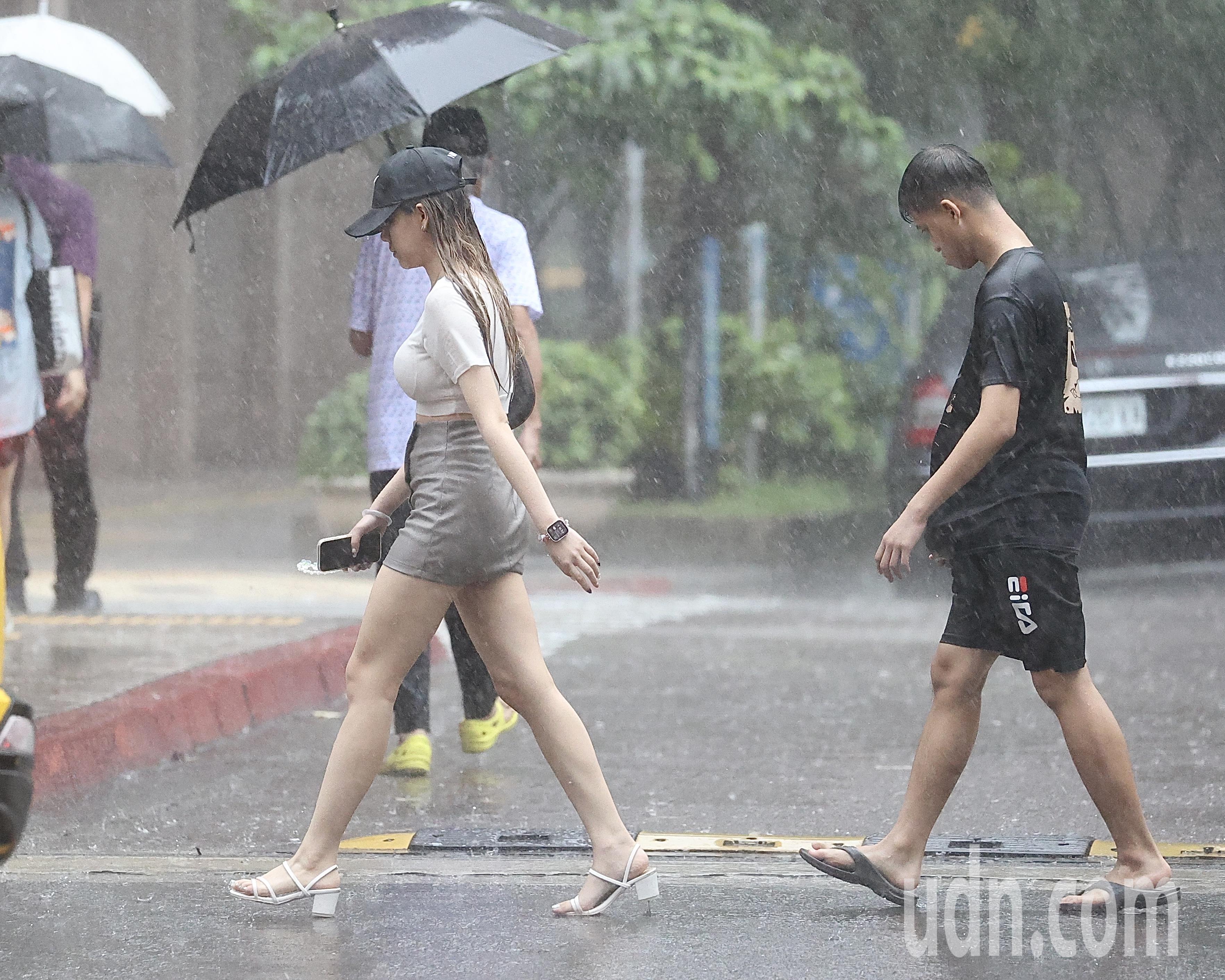 近期台湾处在太平洋高压边缘偏南风环境中，中央气象署针对11县市发布大雨特报，影响时间从今日下午至晚上。图为台北民众没带雨具，在雨中行走。记者林伯东／摄影