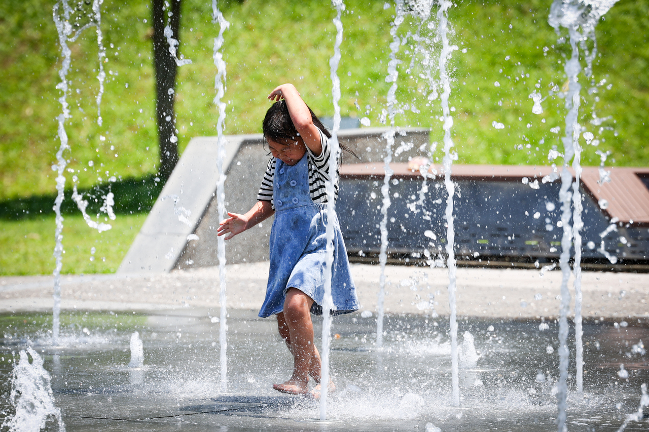 极端高温频传，全台热成烧蕃薯。图为新北市土城区一处公园，孩童穿梭水柱间戏水消暑。中央社