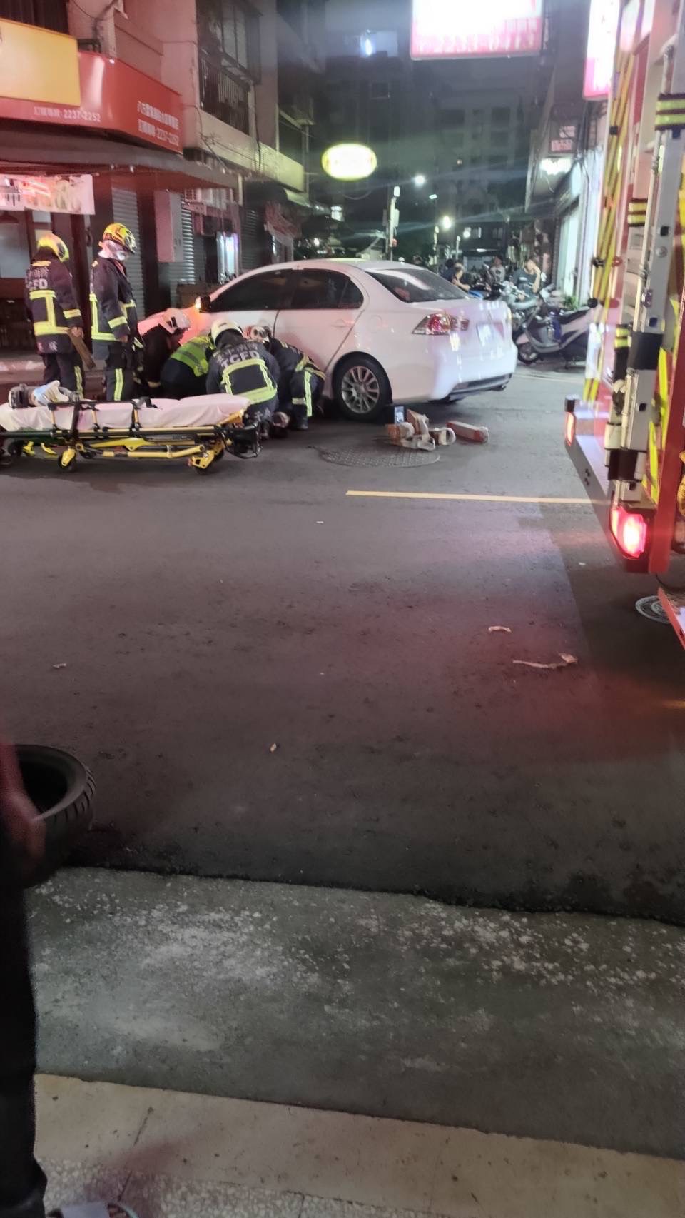 台中市北区梅亭东街在今晚7时许传出车祸，一名七旬妇人卡在车底，警消抢救中。图／读者提供