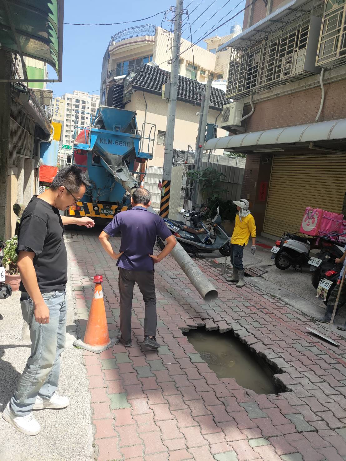 台南市北区北华街一处建案工地附近，今早9点多传出红砖道路面突然下陷，凹出1个约1公尺的坑洞。图／民众提供