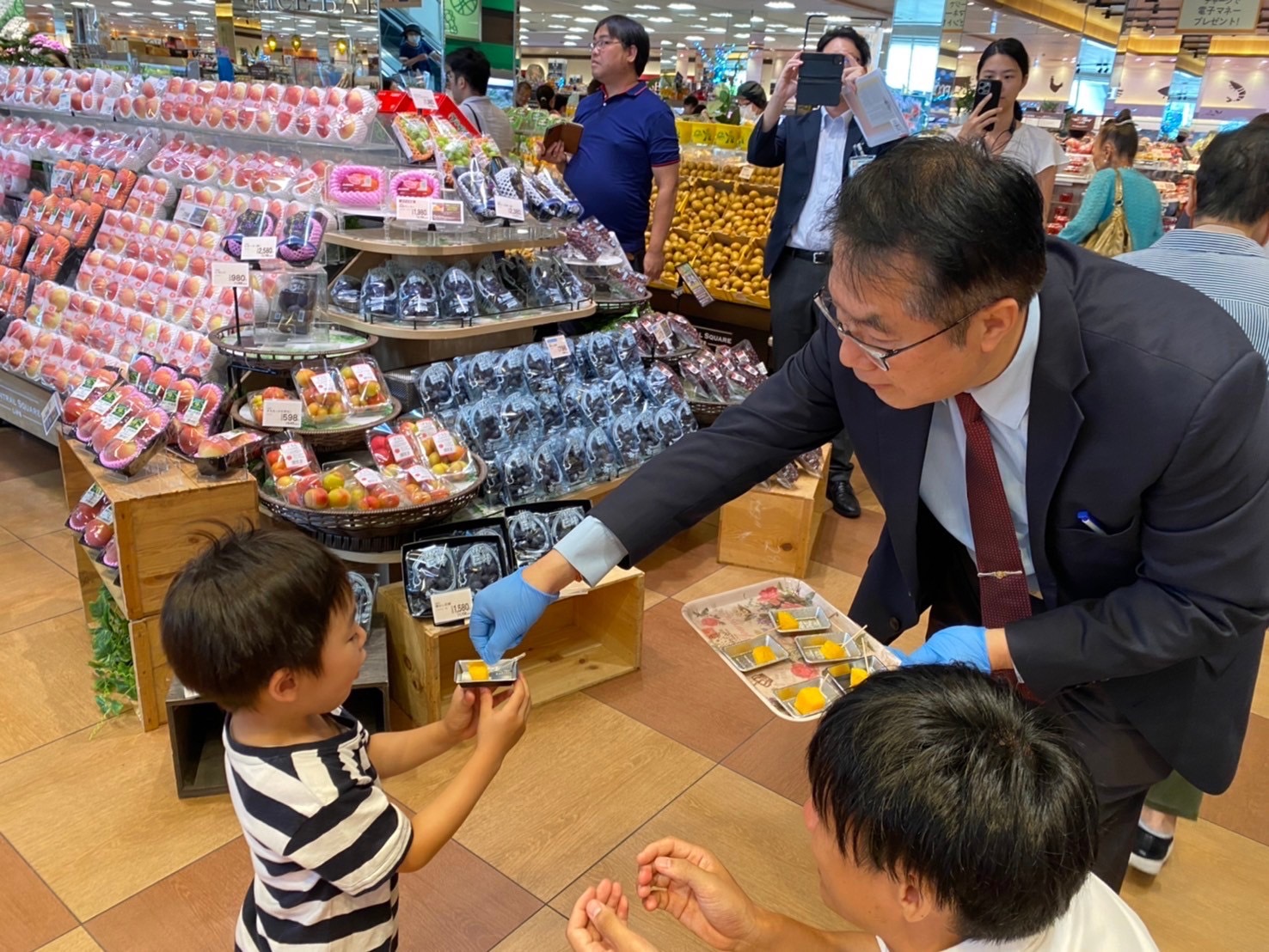 台南芒果成功进军日本关西地区，在知名连锁超市上架，市长黄伟哲前往了解销售情形，并请吃芒果。图／南市府提供