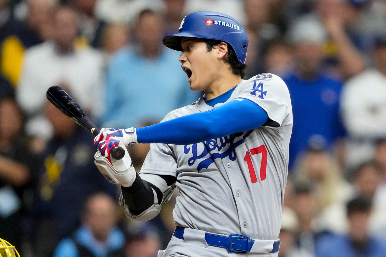 Shohei Ohtani swinging in a Los Angeles Dodgers uniform during postseason baseball
