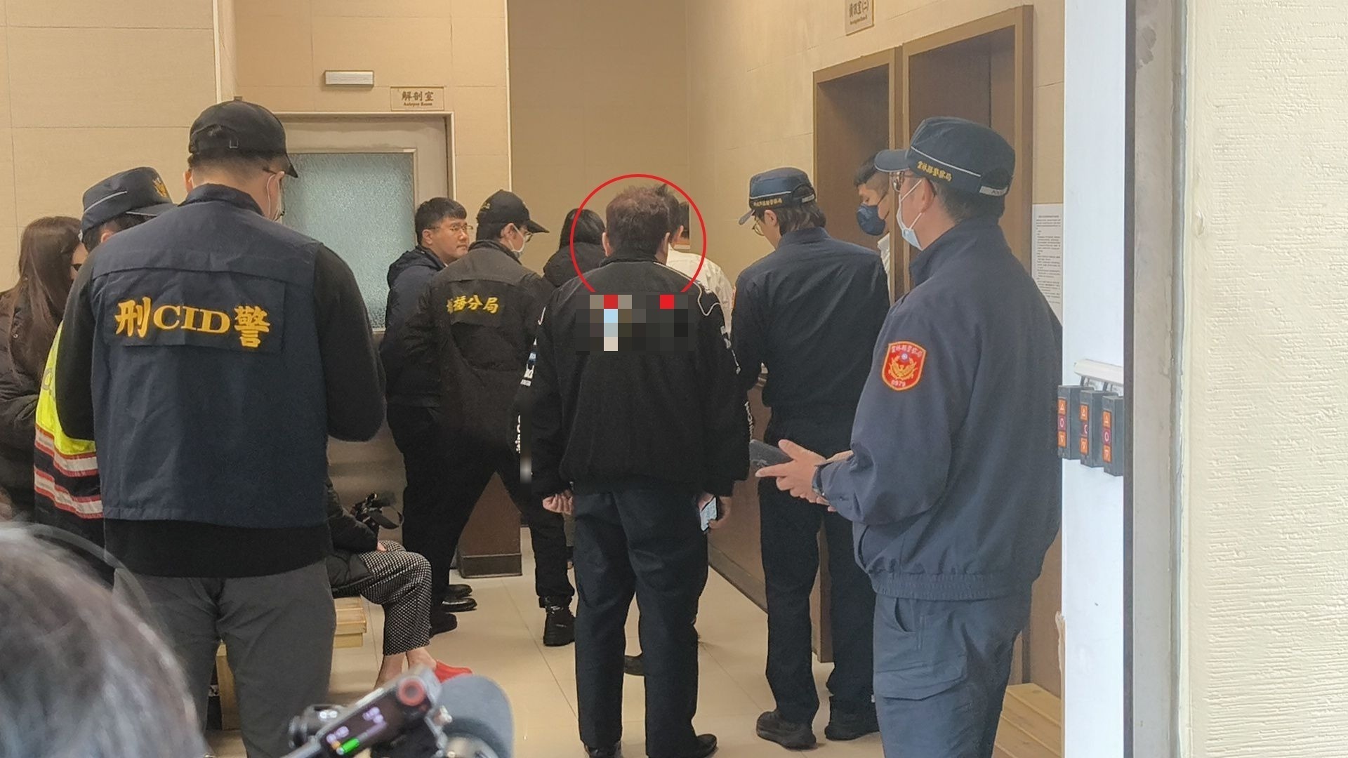 周父(红圈处)身穿保全员制服在殡仪馆等待相验。记者黄子腾／摄影