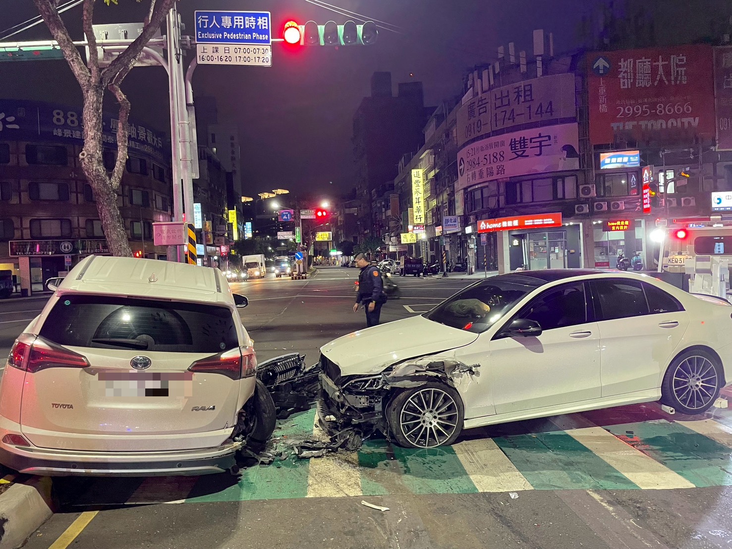 新北市三重区昨晚有1辆白色宾士轿车（右）把前方路口好端端停等待转的休旅车，猛然撞上安全岛，27岁肇事驾驶接受酒测却宁愿被开罚18万元、扣车扣牌吊销驾照，拒绝唾液快筛验毒。记者林昭彰／翻摄