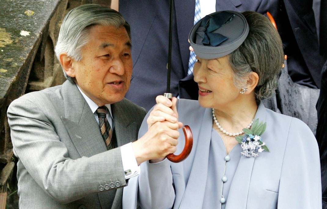 日皇明仁及皇后美智子在訪問英國牛津大學三一學院時,共撐一把傘。法新社