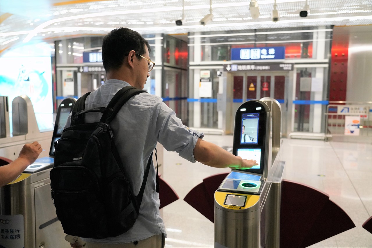 北京地铁大兴机场线「刷掌乘车服务」21日上线。图为乘客在大兴机场站刷掌过闸。（新华社）