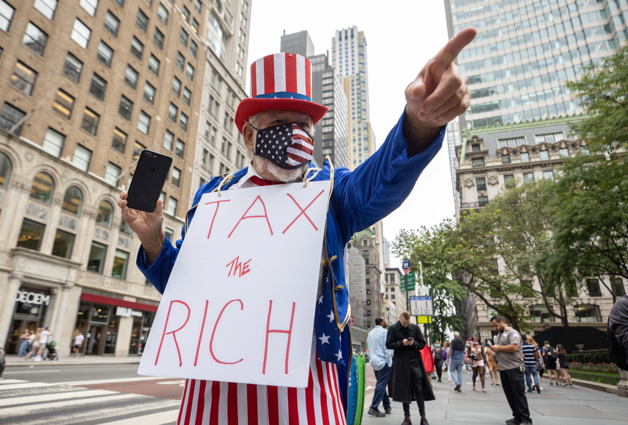 民众在曼哈顿街头示威要求加征富豪税。六成人误以为中等收入家庭承担最大税务，其实收入前50%的人贡献了联邦税高达近98%，(路透)