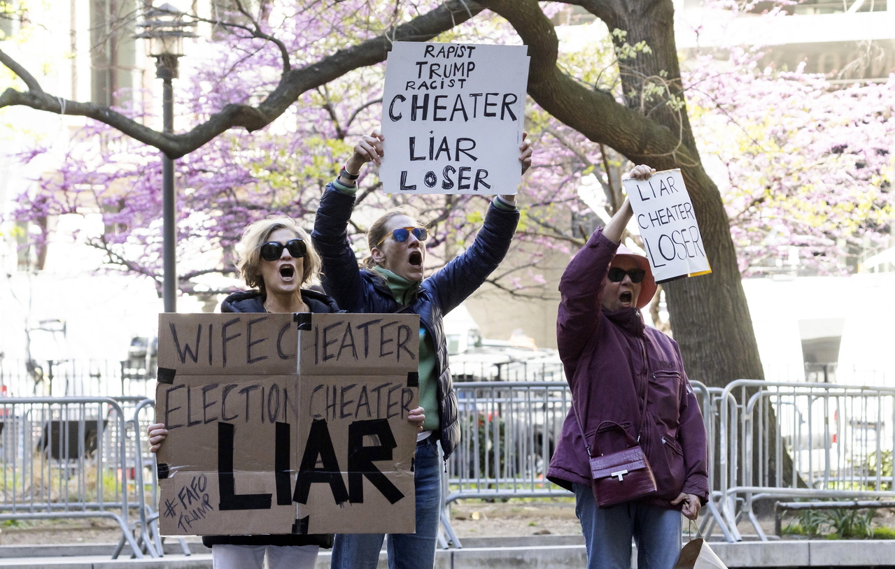 新闻媒体各有立场，对川普封口费案的报导方式有严重分歧；图为三名女性在曼哈顿刑事法院外举牌，称川普「说谎者」。欧新社