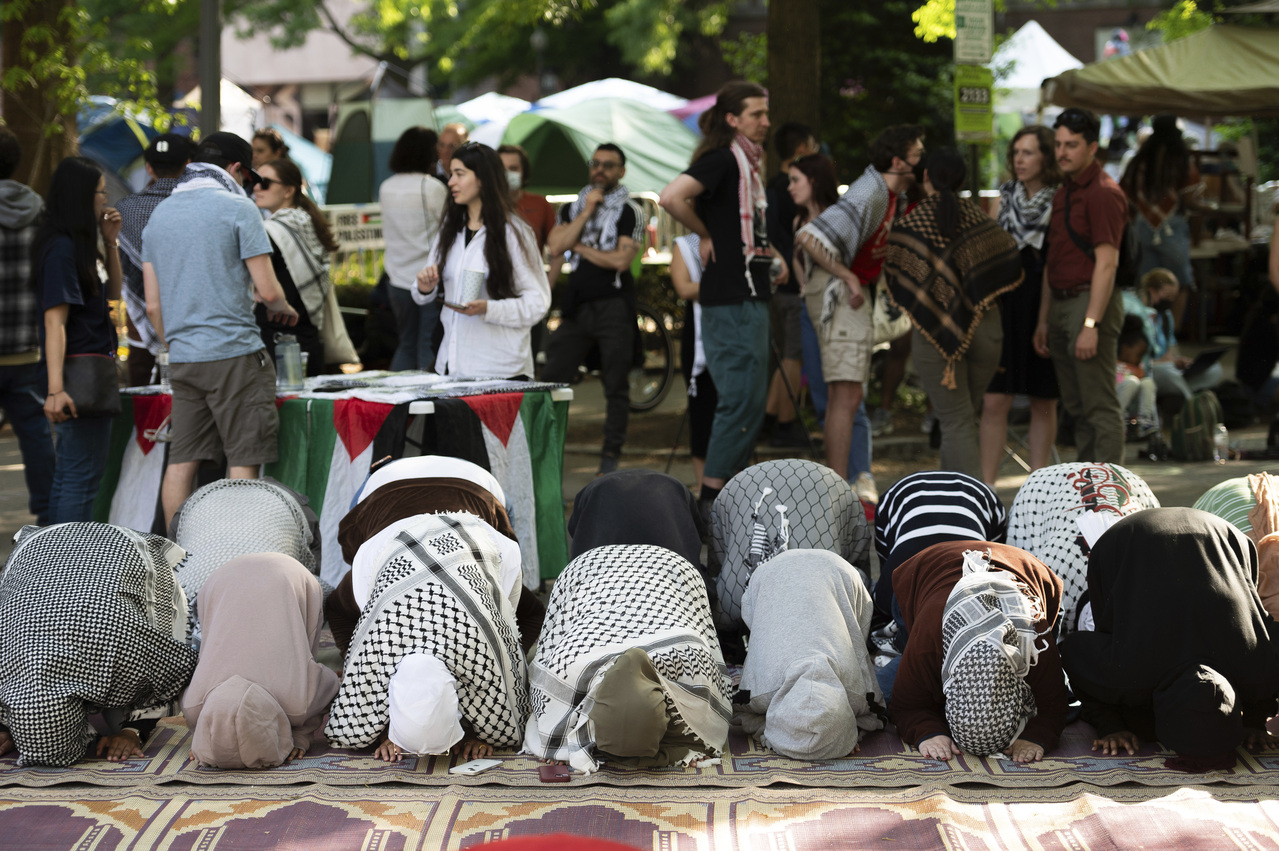 穆斯林社团人士与反犹反以挺巴的示威学生28日在乔治华盛顿大学校园里祈祷。(美联社)