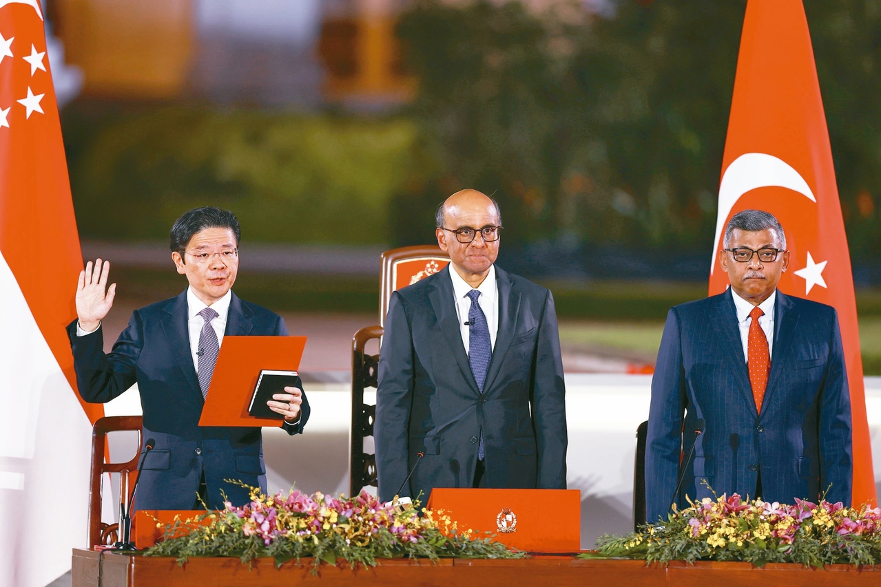 时代翻过新篇章 新加坡新任总理兼财政部长黄循财（左）15日宣誓就职。（欧新社）