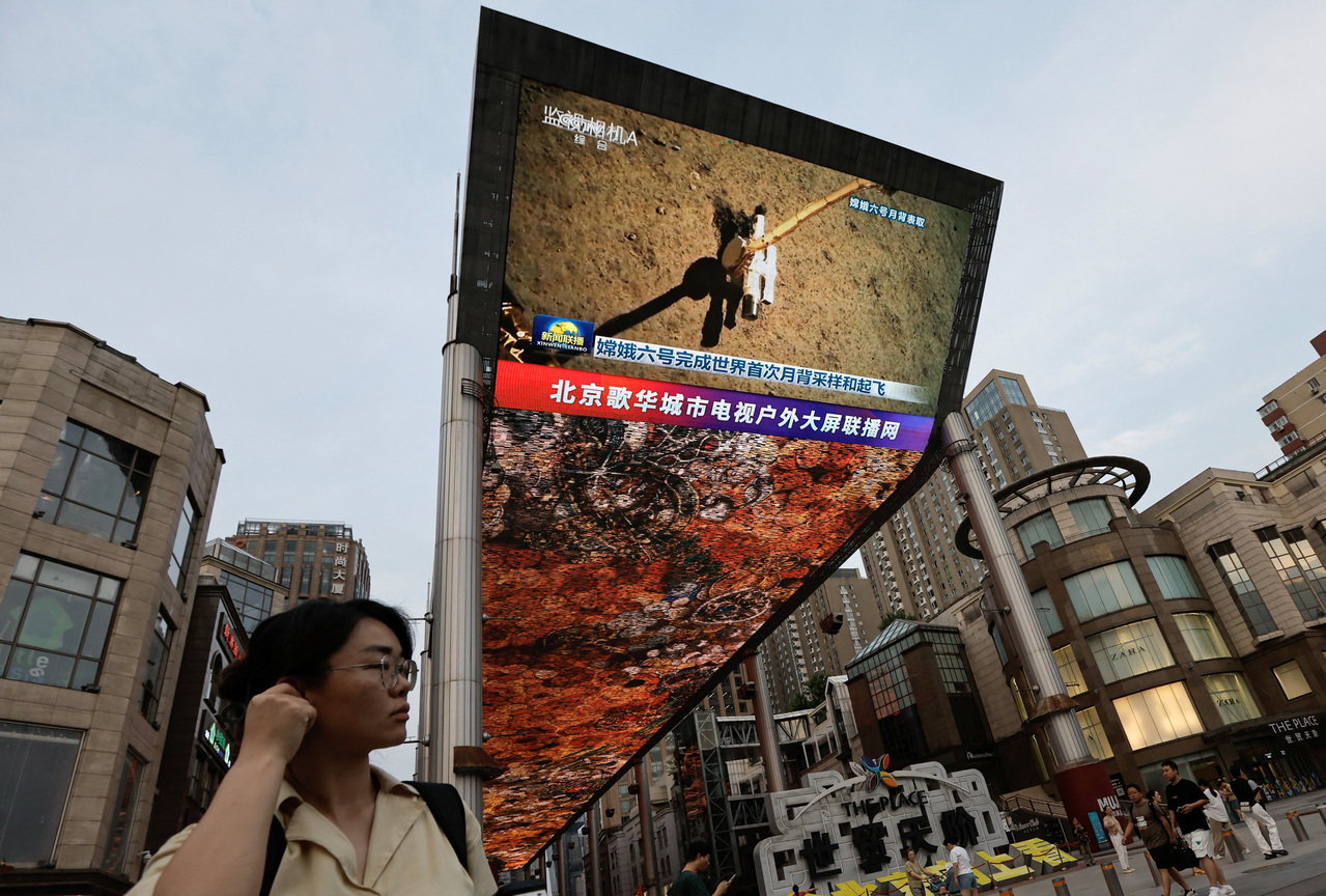 英媒称中国已是科学超级大国。图为北京一广场的大型电视墙正直播中国「嫦娥六号」完成世界首次月背采样的现场画面。(路透)