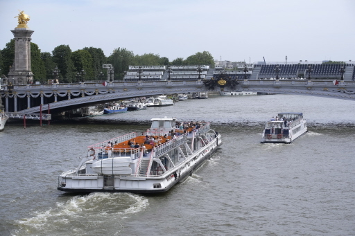 巴黎奥运即将到来，塞纳河水中的大肠杆菌连续第三周出现不安全水平，引发外界担忧；图为游客28日搭船驶过亚历山大三世桥。 （美联社）